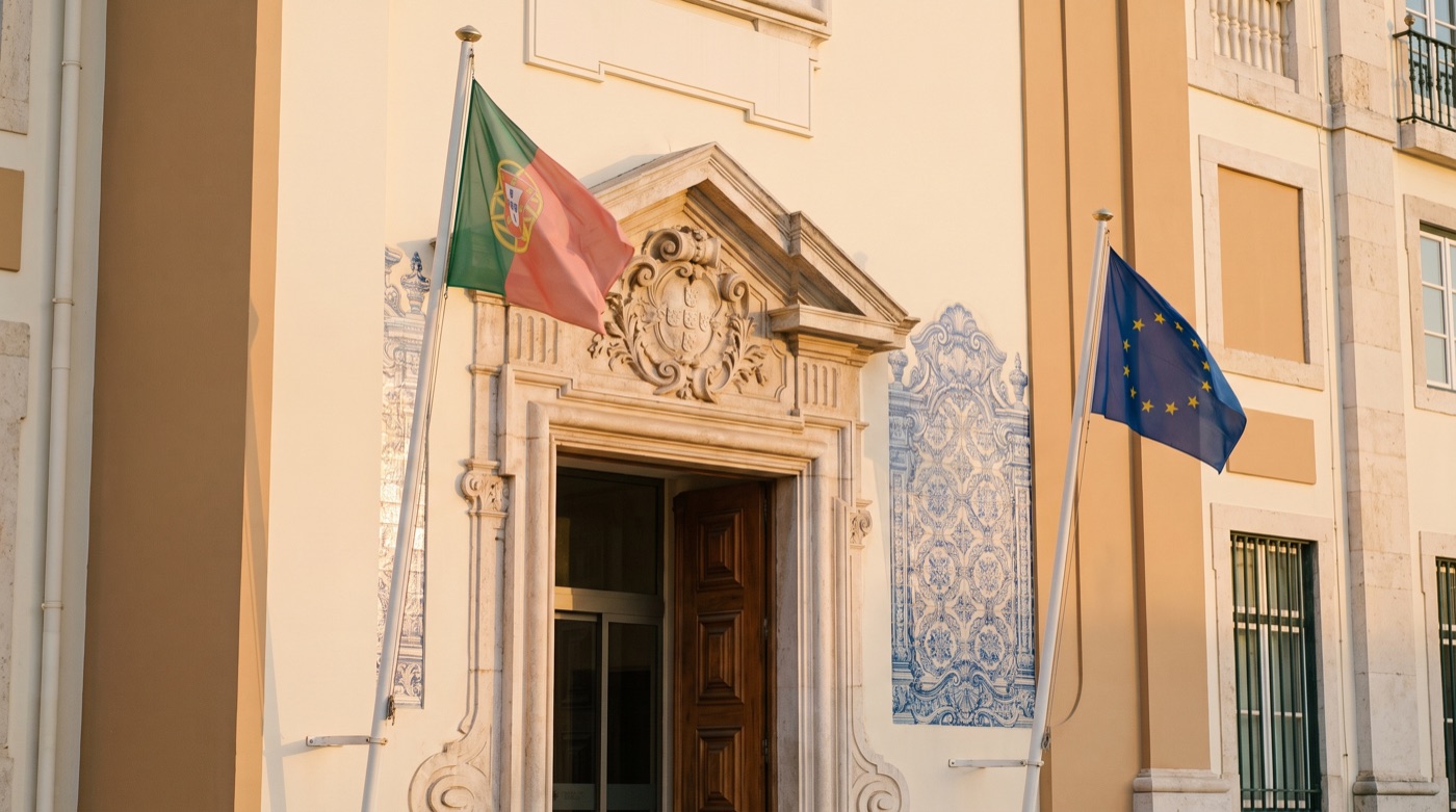 Portuguese and EU flags on a government building entrance in Lisbon